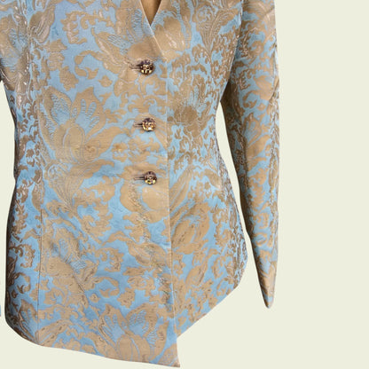 Light blue and gold jacket with button detail on a beige background