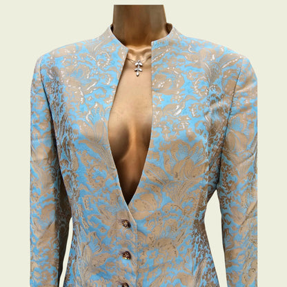 Mannequin wearing a light blue and gold jacket on a beige background