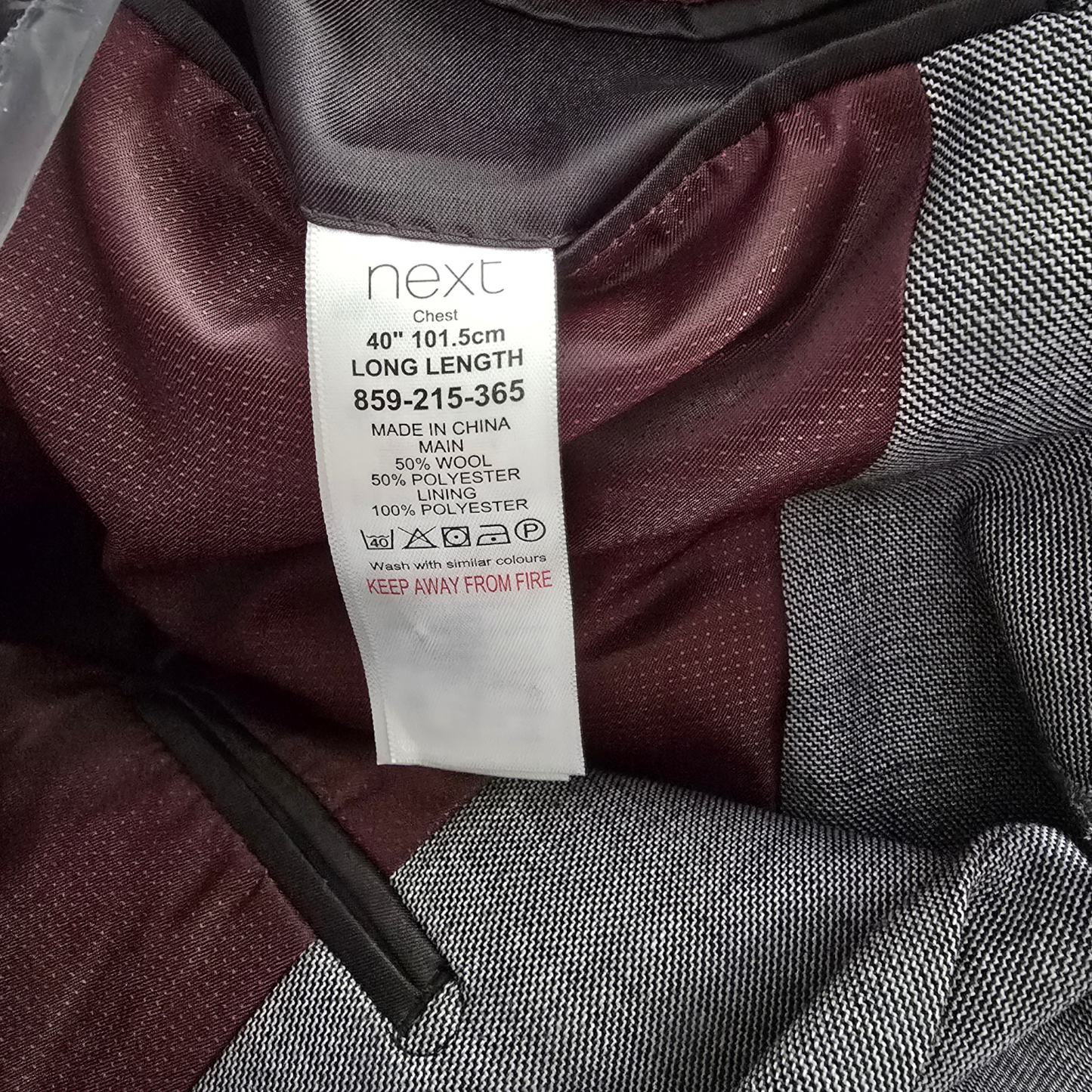 Clothing label on a maroon and gray fabric background