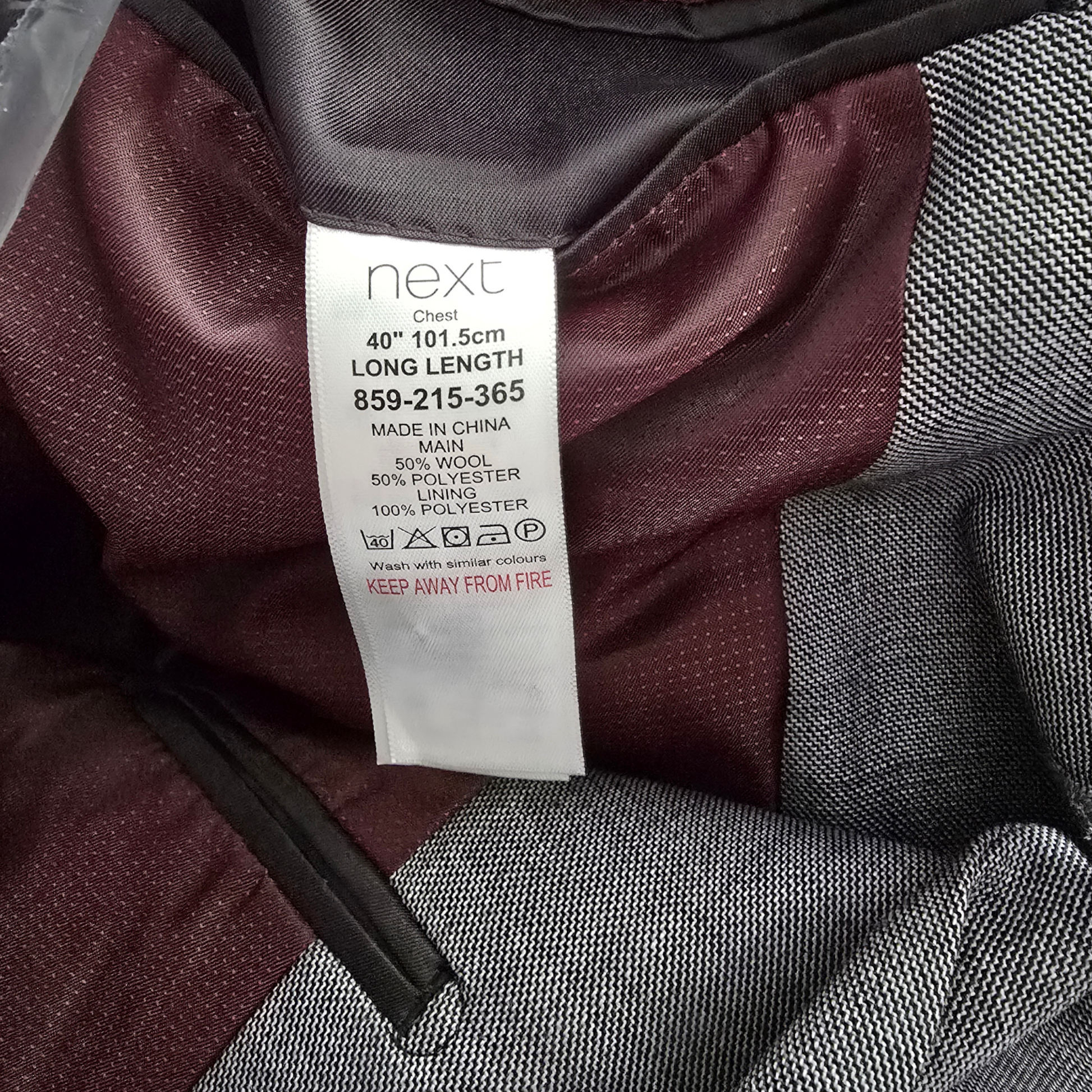 Clothing label on a maroon and gray fabric background