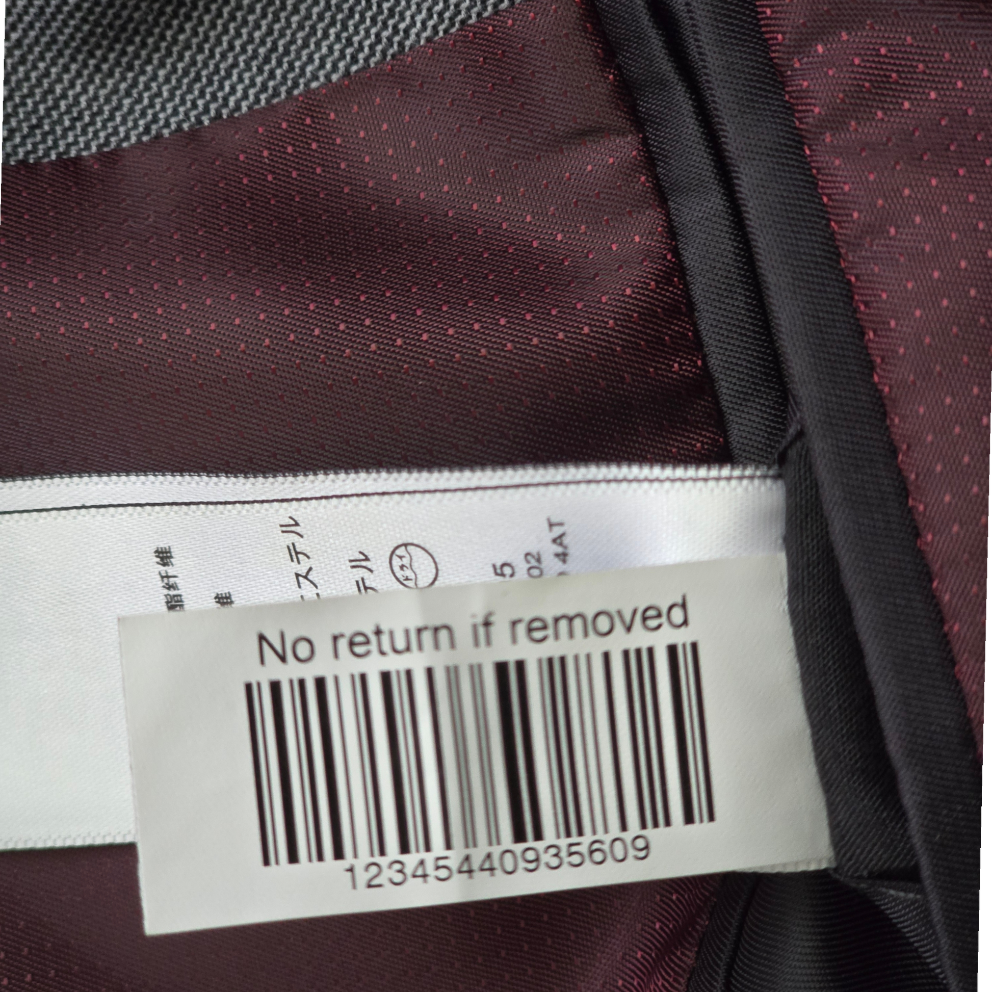 Close-up of a label on a garment with text and a barcode.