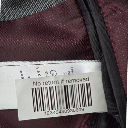 Close-up of a label on a garment with text and a barcode.