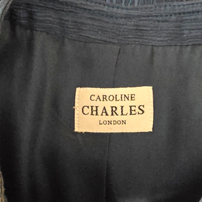 Label with 'Caroline Charles London' on a dark fabric background