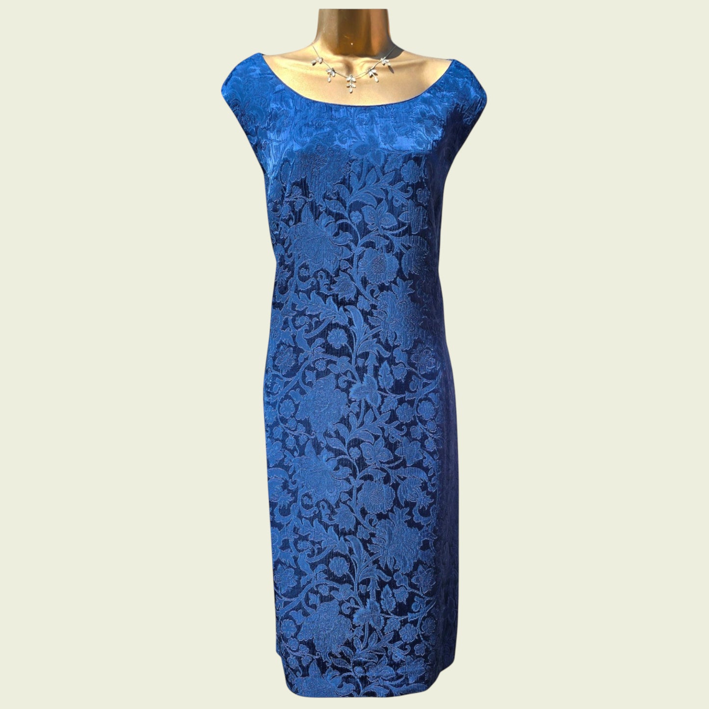 Mannequin wearing a midnight blue dress on a beige background