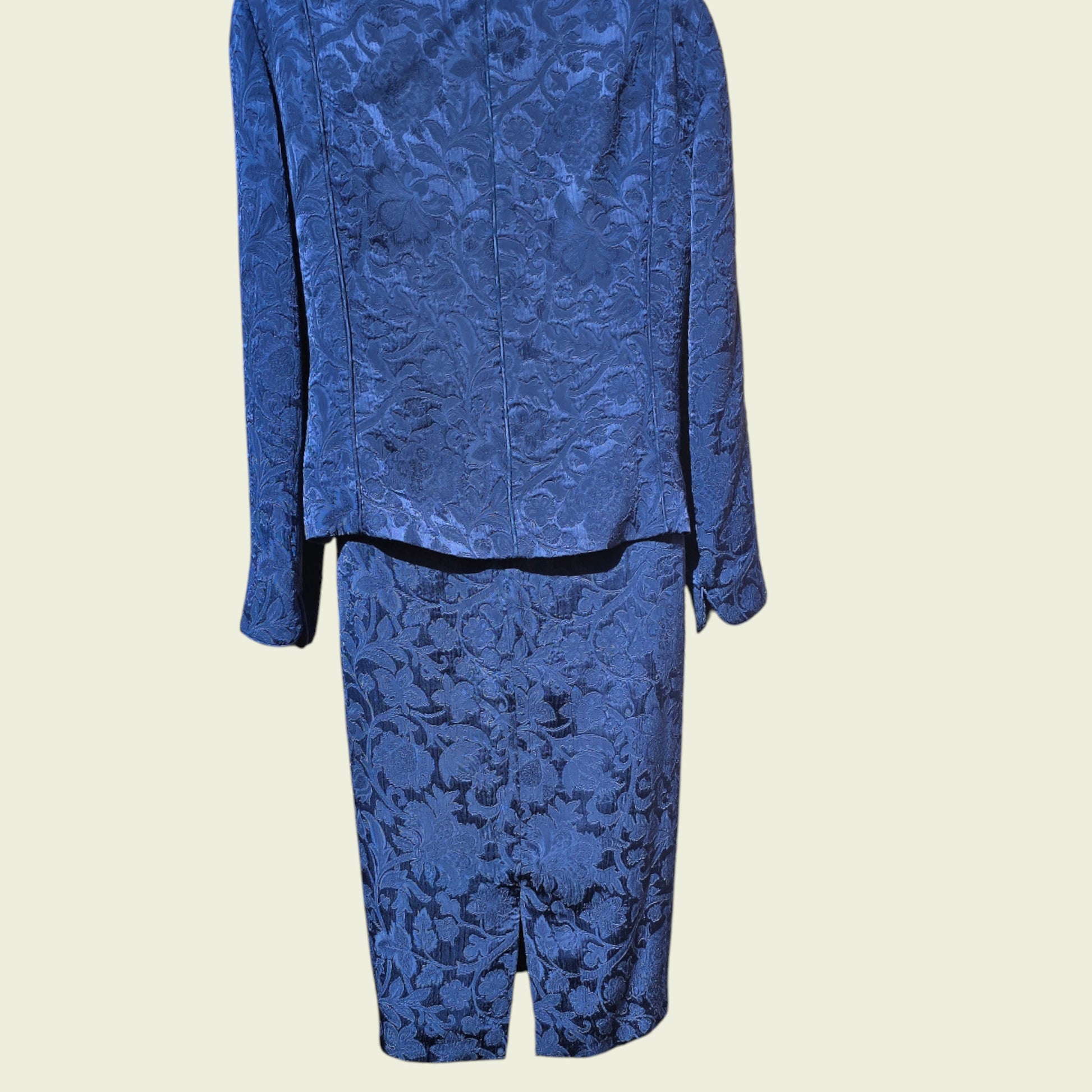 Mannequin wearing a midnight blue dress and jacket on a beige background