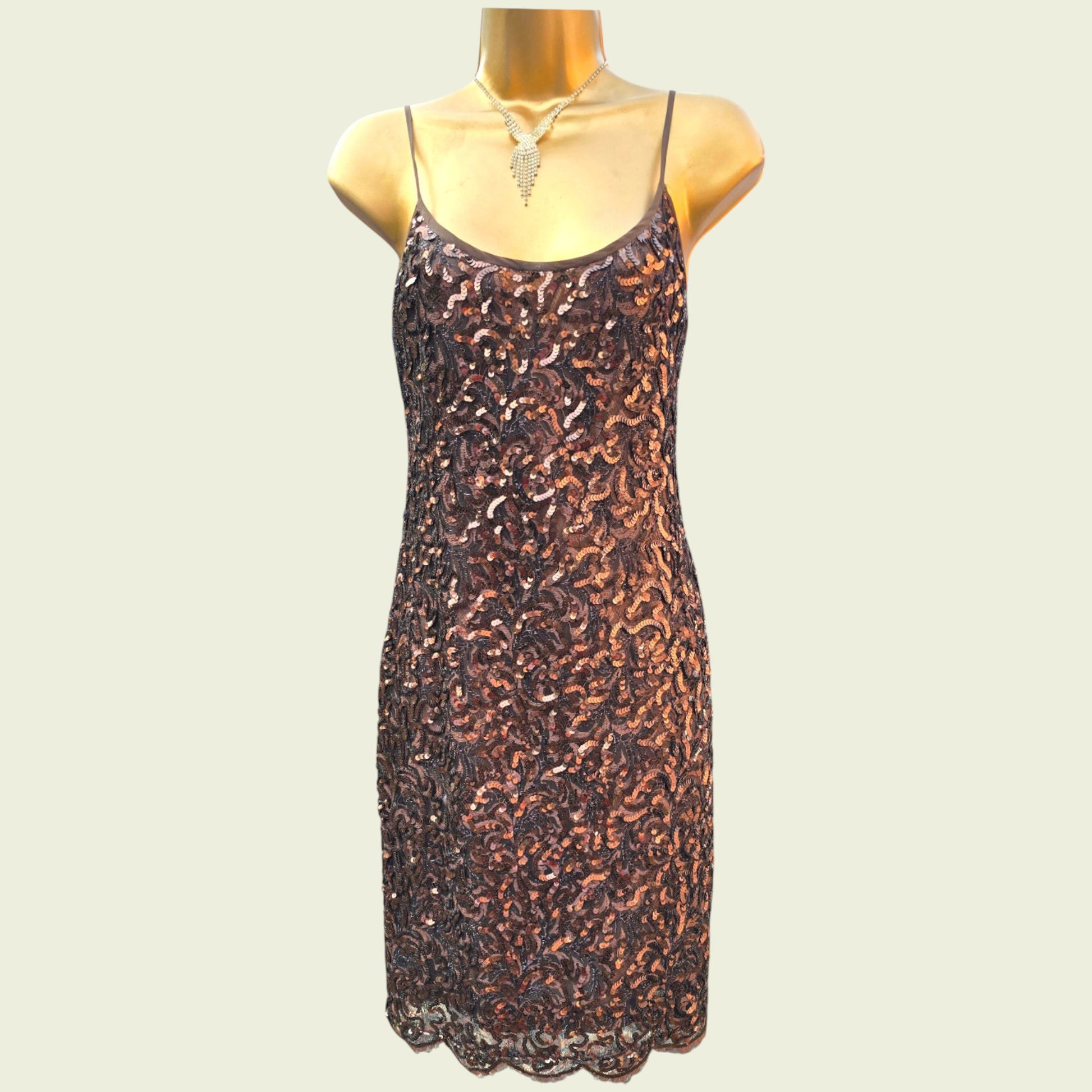 Sequinned dress on a mannequin against a plain background