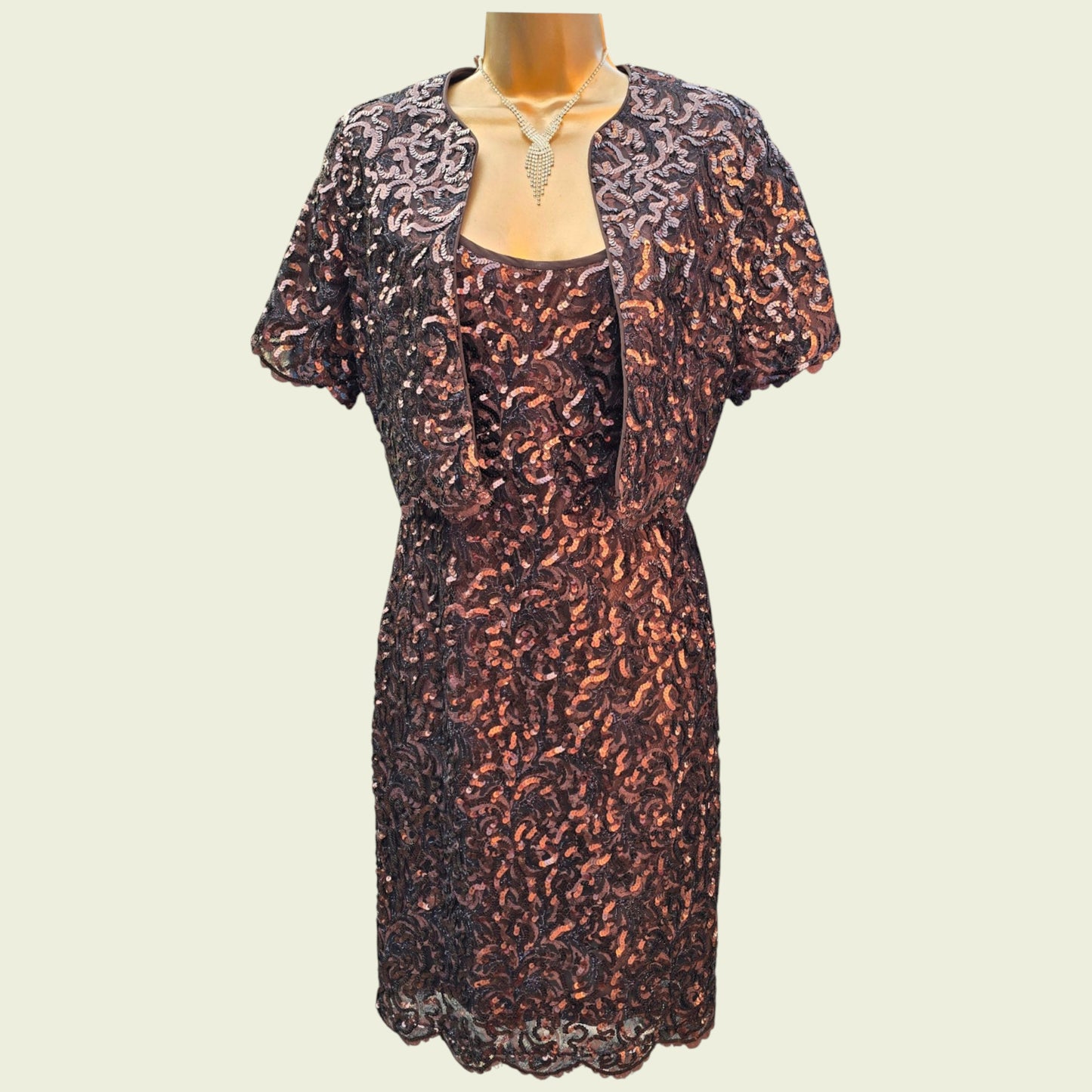Sequinned dress with matching jacket on a mannequin against a beige background