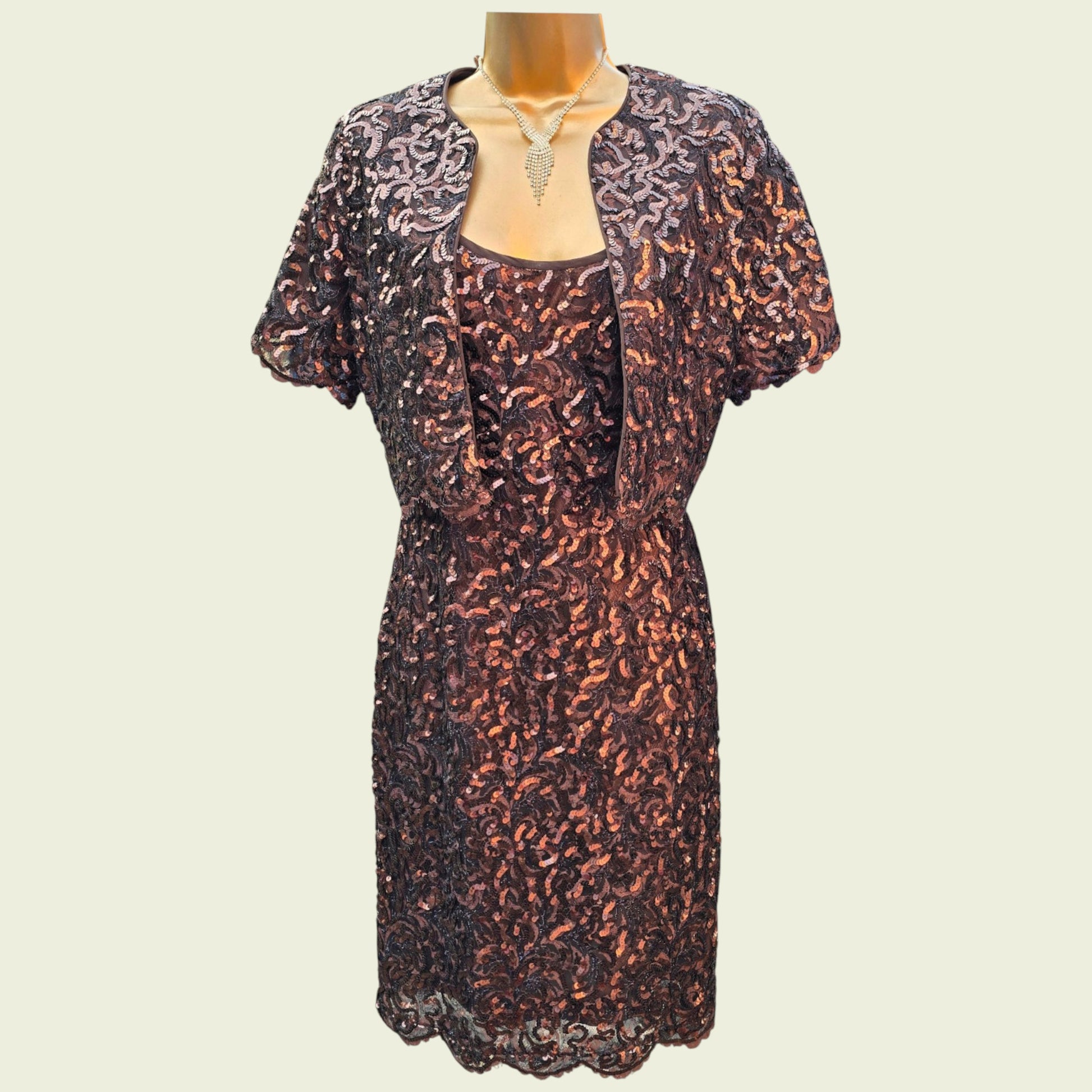 Sequinned dress with matching jacket on a mannequin against a beige background