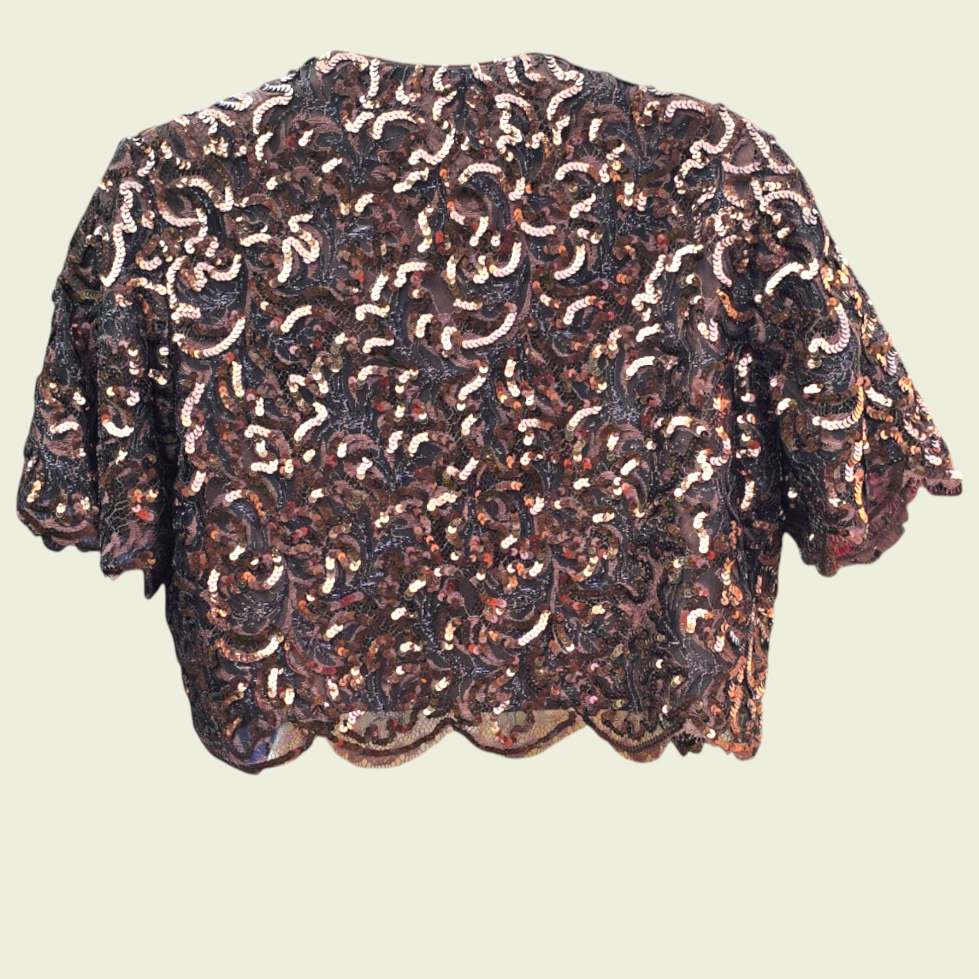 Sequinned bolero jacket on a beige background