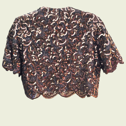 Sequinned bolero jacket on a beige background
