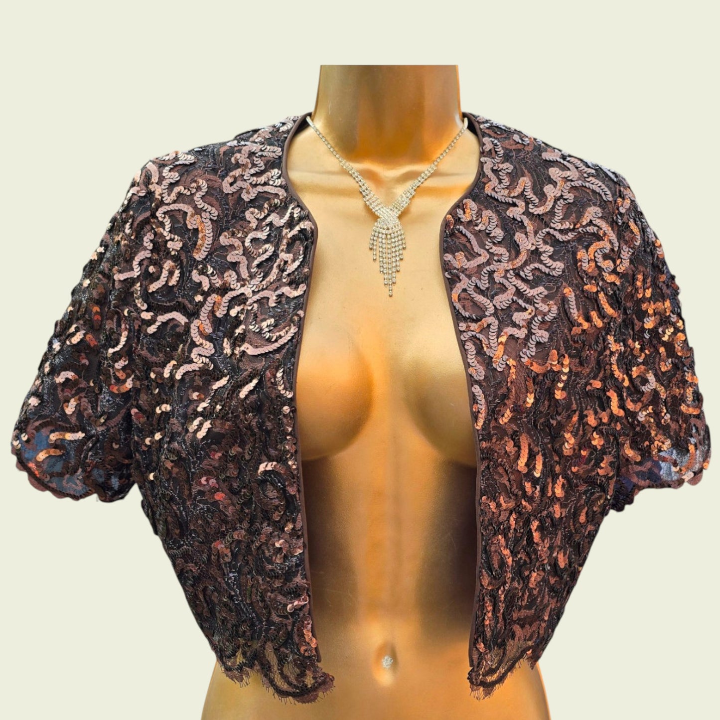 Decorative sequinned bolero on a mannequin with a neutral background