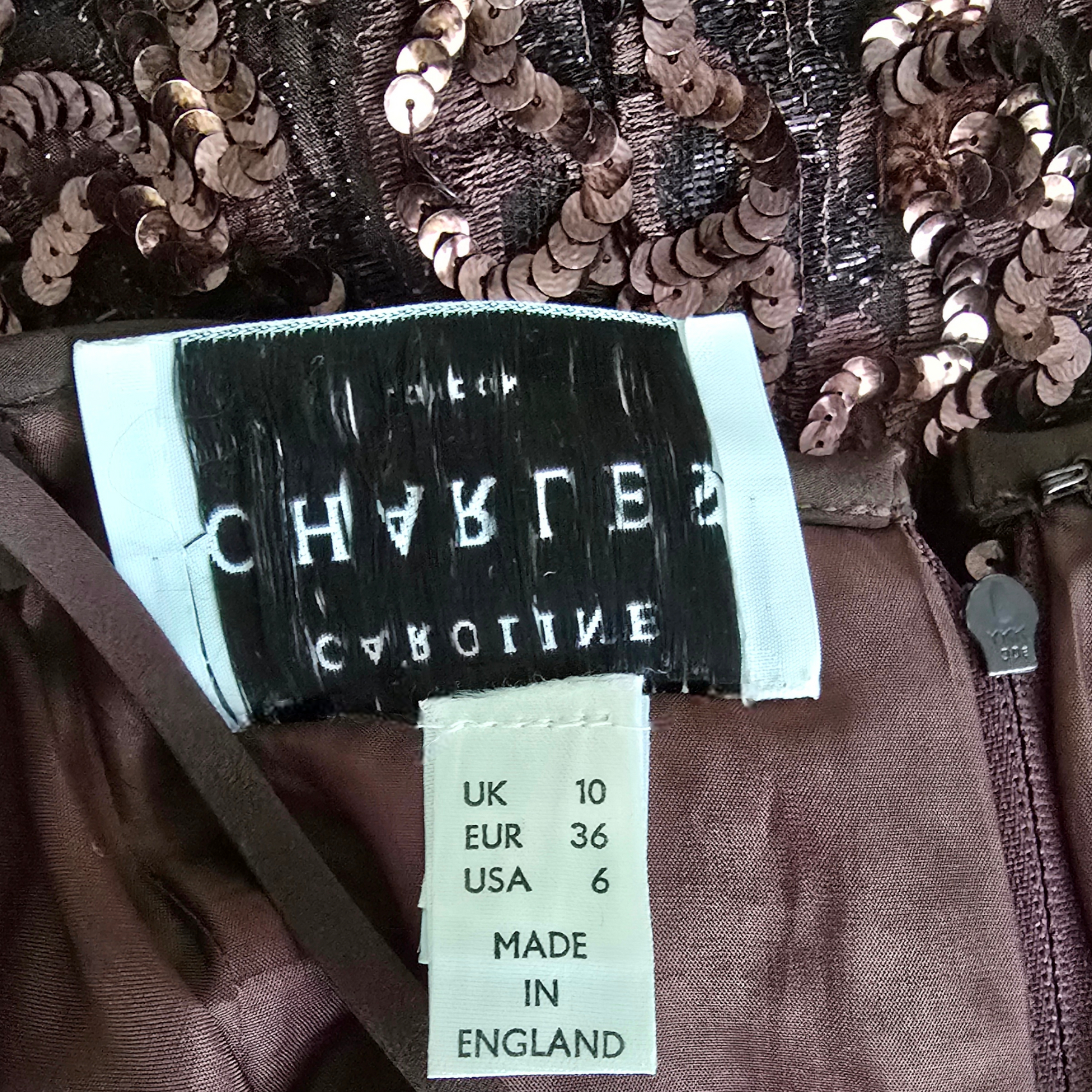 Close-up of a sequined garment with a label displaying brand name and size information.