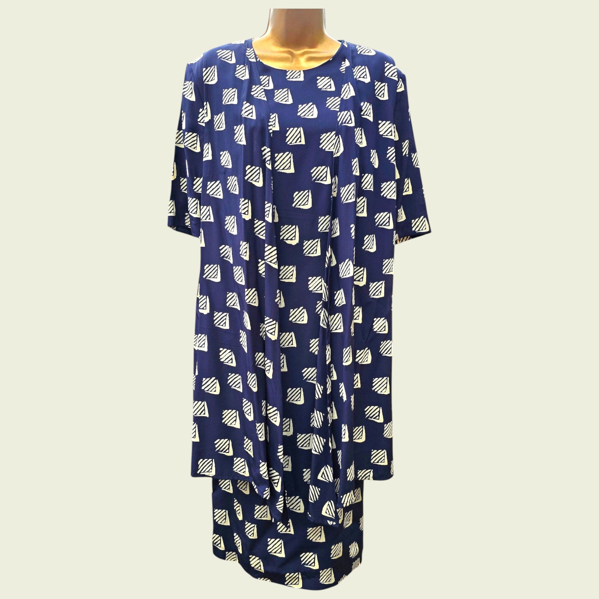 Blue dress with white geometric pattern on a mannequin against a white background