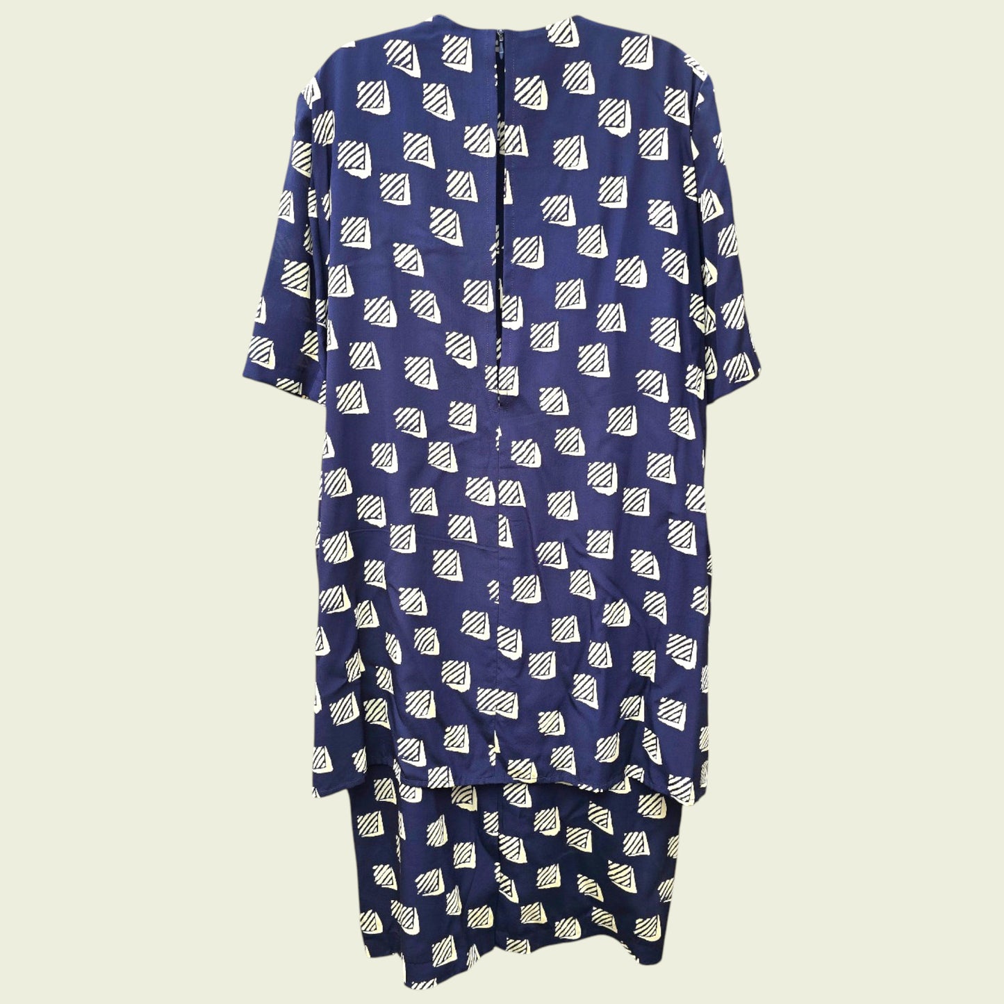 Navy blue dress with white geometric pattern on a beige background
