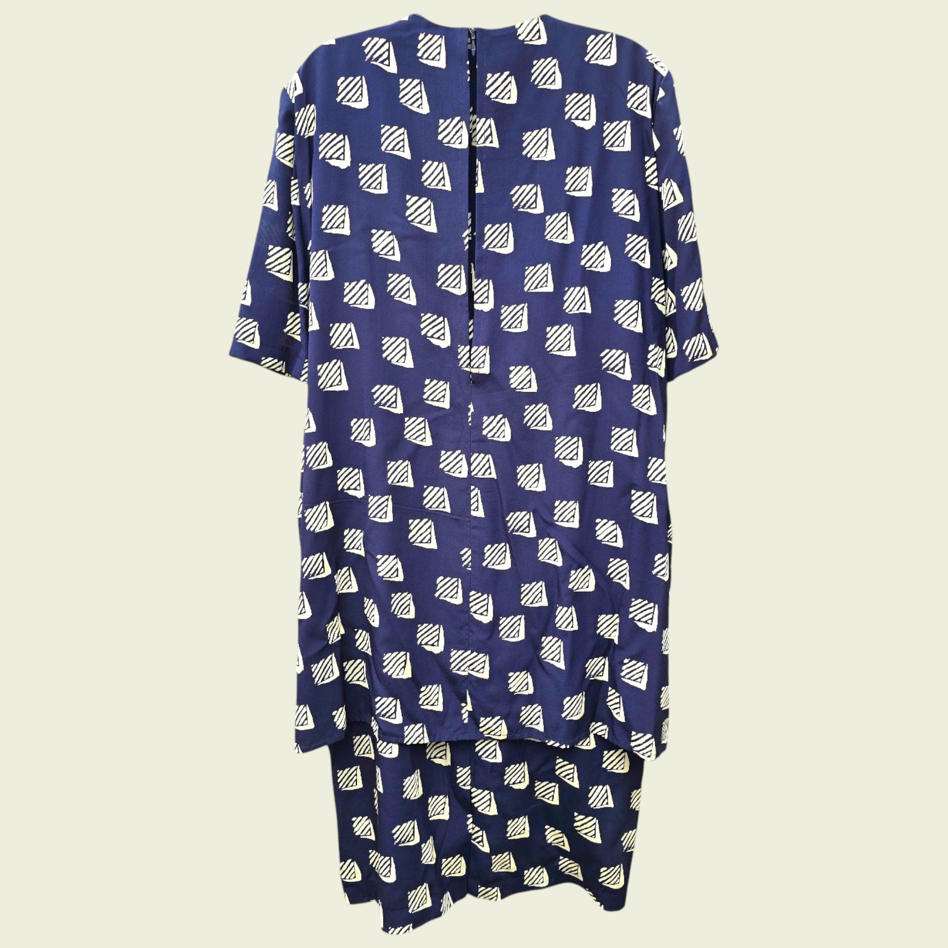 Navy blue dress with white geometric pattern on a beige background