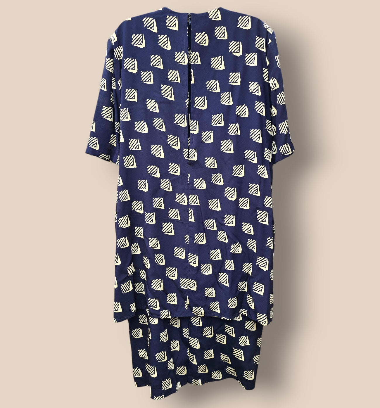 Navy blue dress with white geometric pattern on a beige background