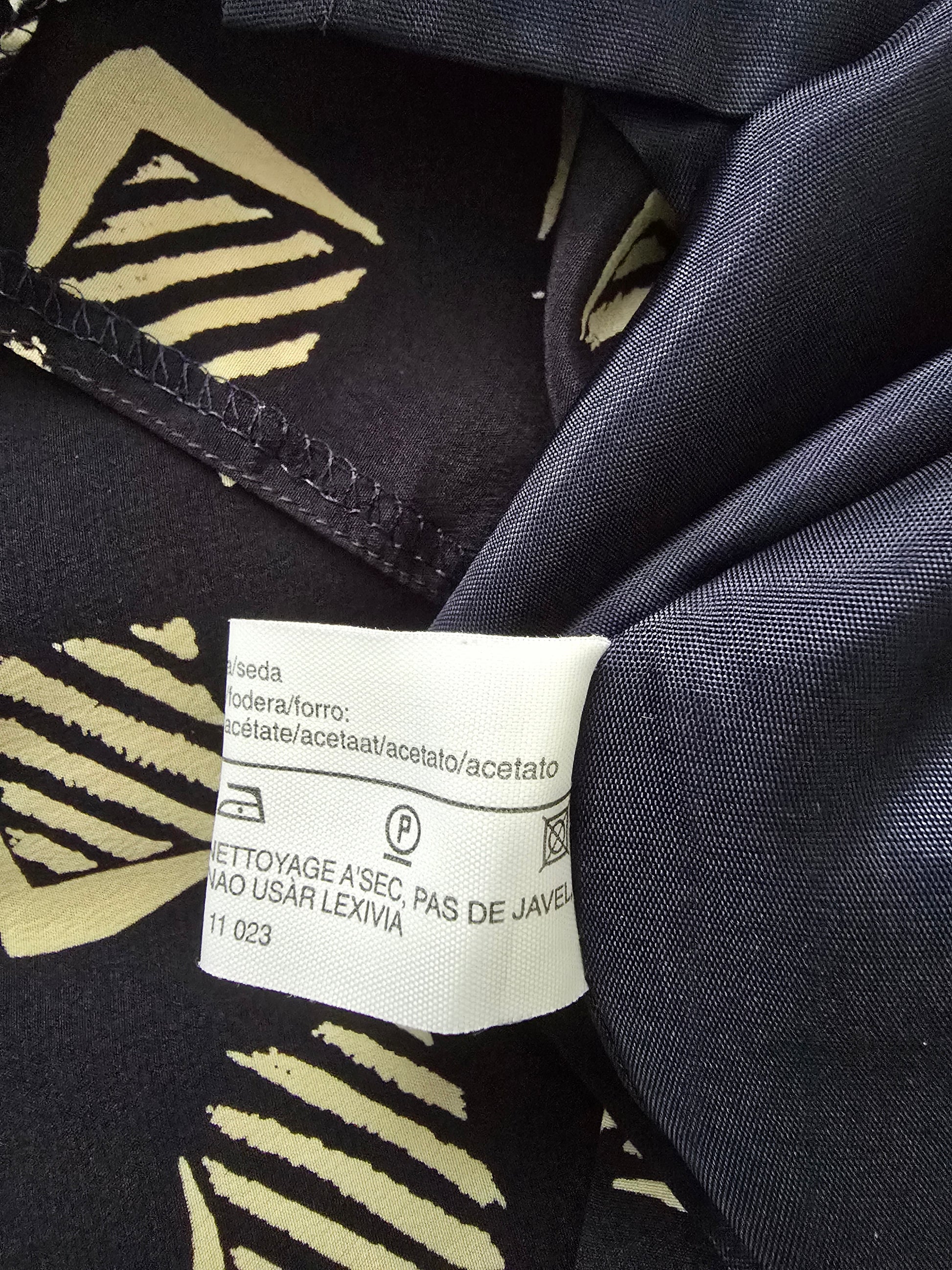 Clothing label on a dark fabric with a pattern