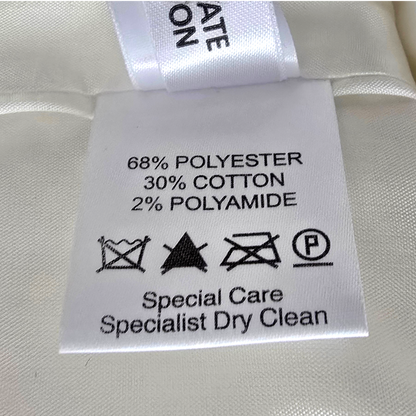 Clothing label with fabric composition and care instructions on a white fabric background