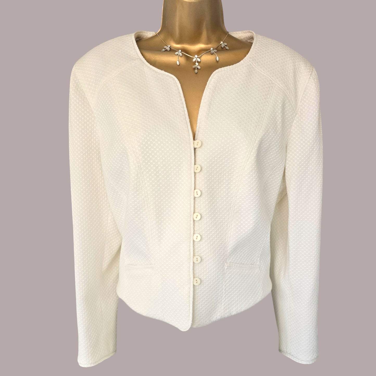 White jacket on a mannequin with a gray background