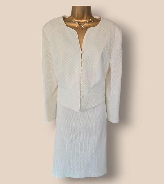 White textured jacket and skirt on a mannequin against a beige background