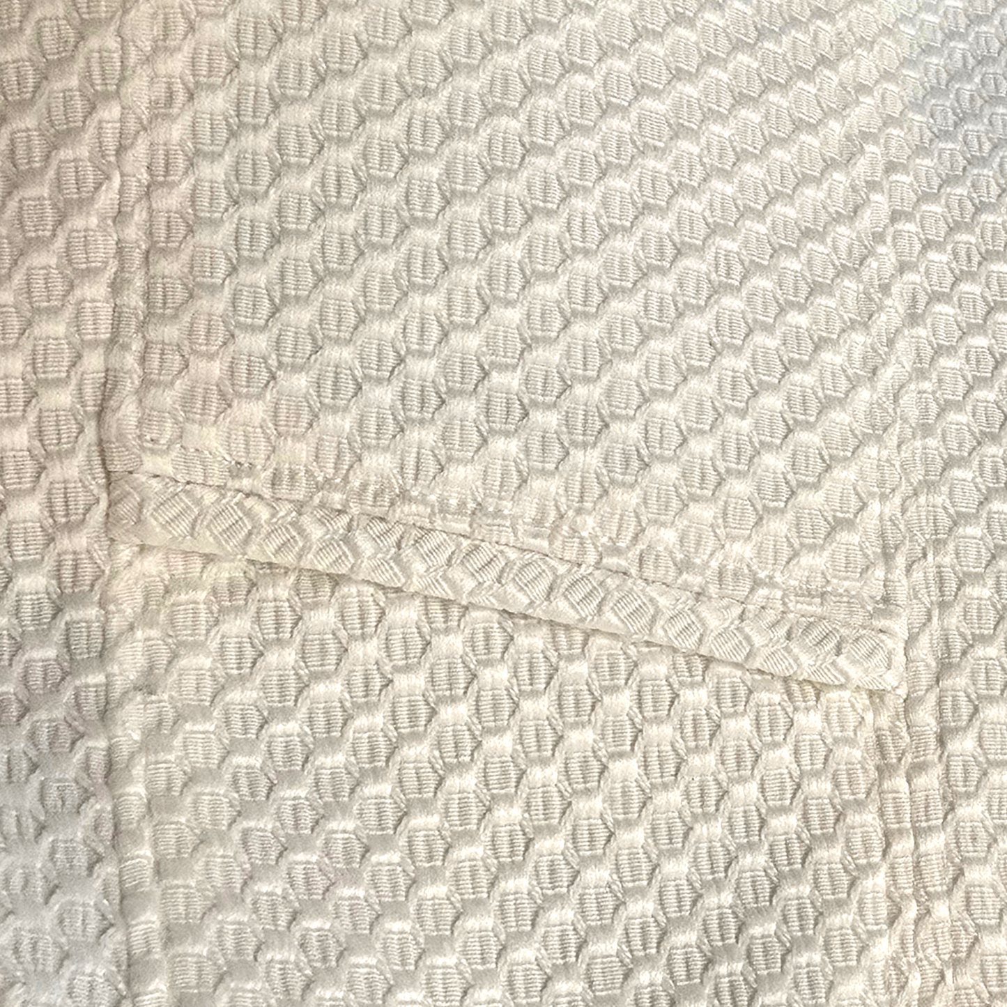 Close-up of textured white fabric with a subtle pattern