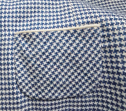 Close-up of blue and white houndstooth pattern fabric with a needle.