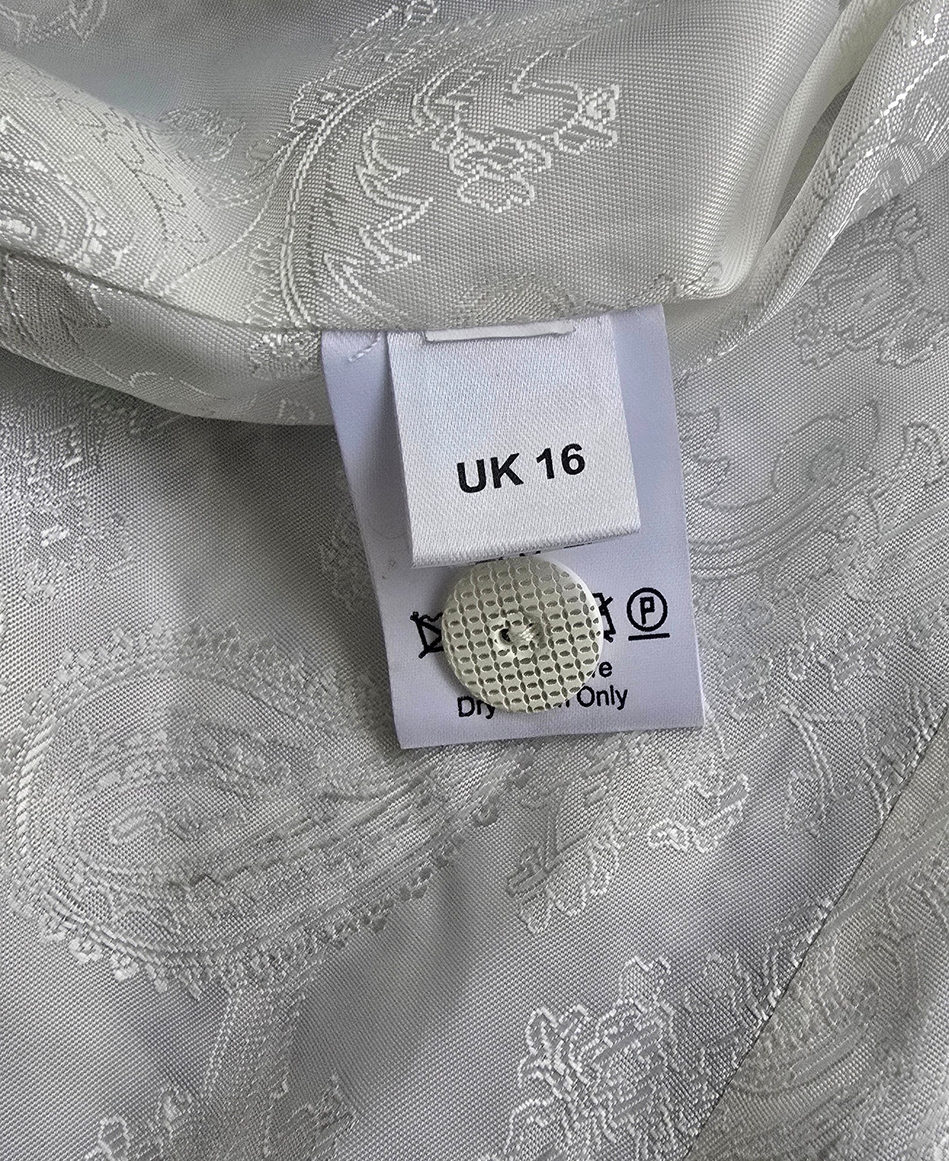 White patterned fabric with a clothing tag and button on top