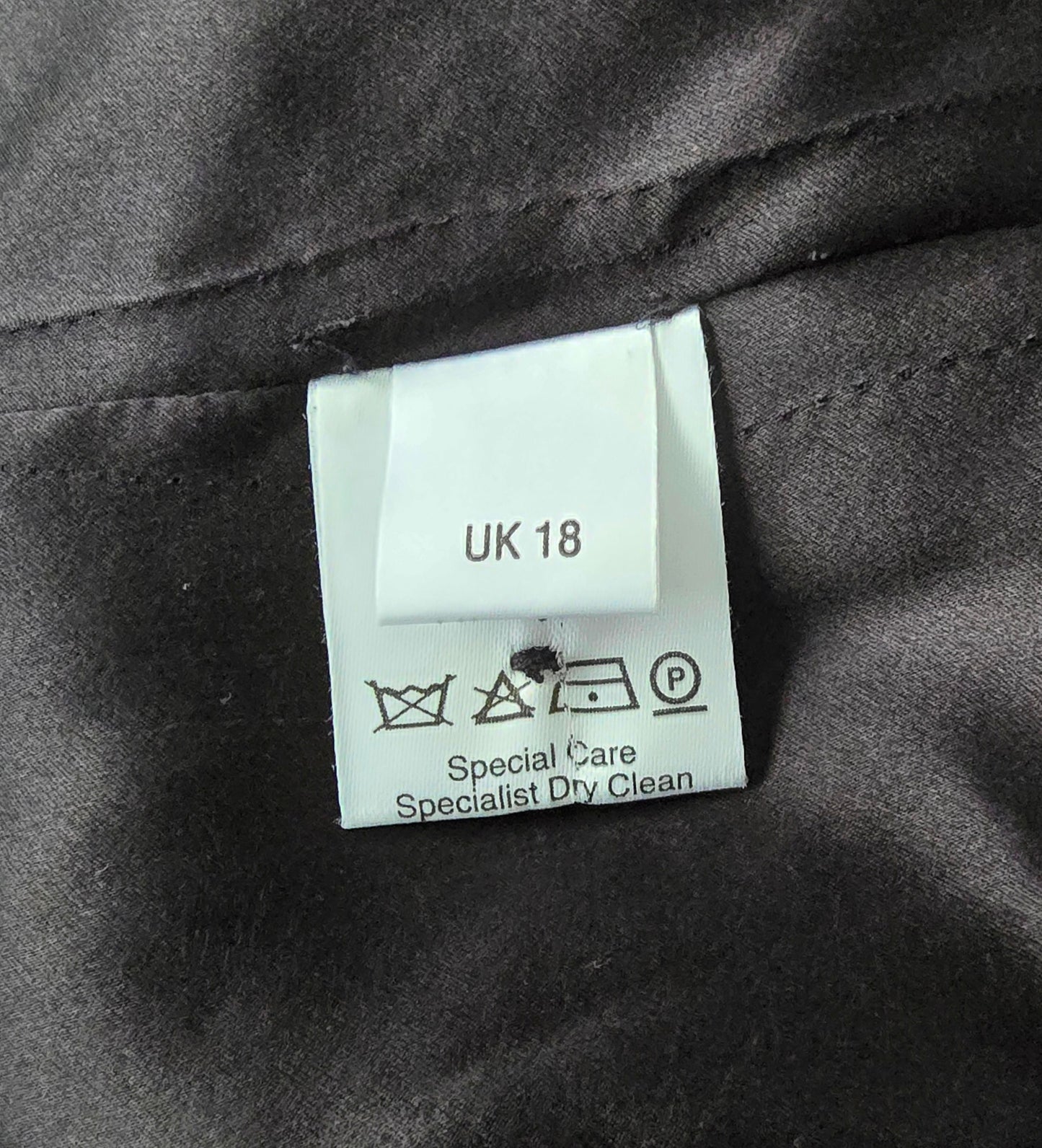 Label showing fabric details and care instructions on black background