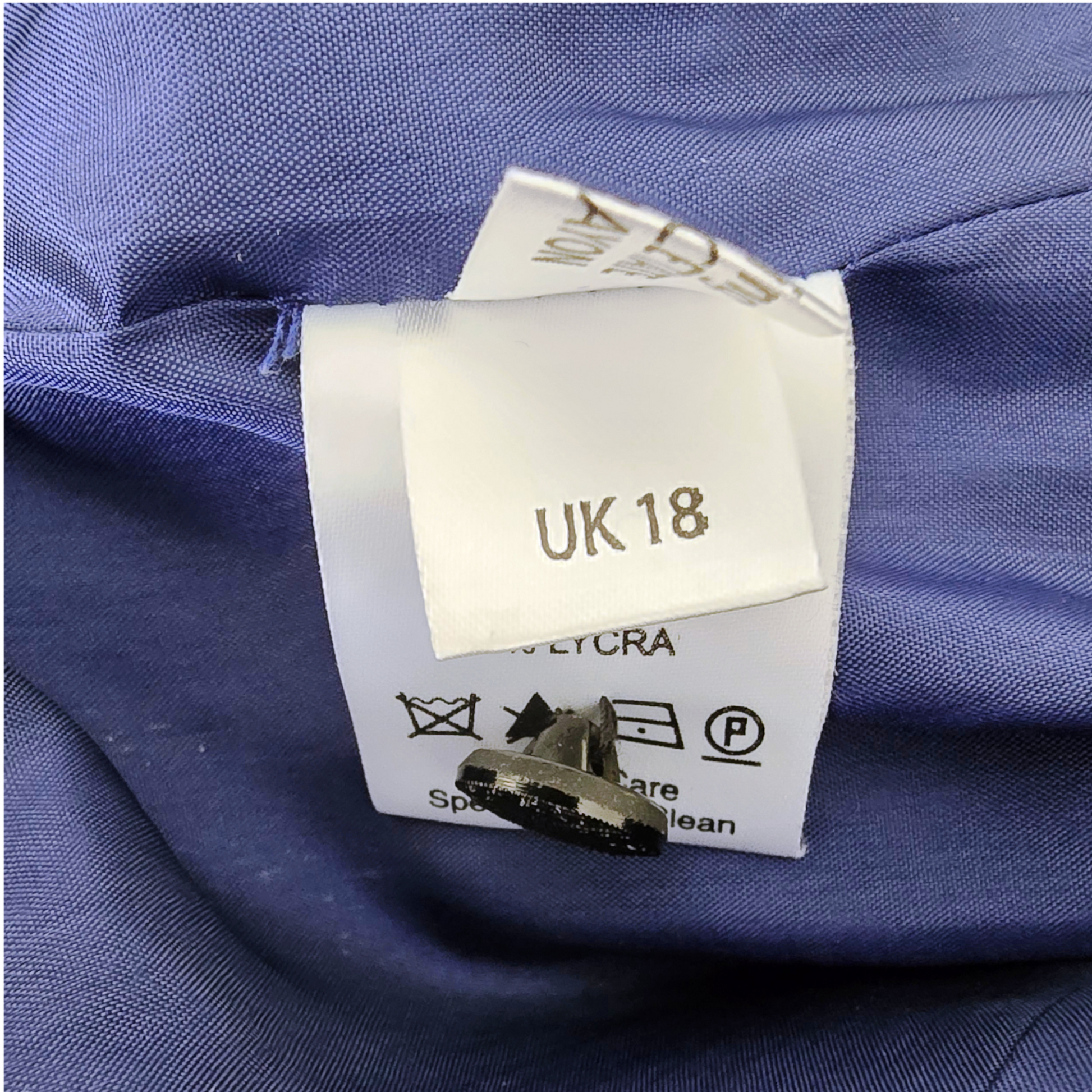 Clothing label with size 'UK 18' on a blue fabric background