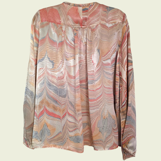 Colorful patterned blouse on a light beige background