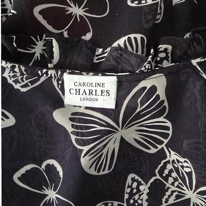 Butterfly patterned fabric with a visible brand label on a black background