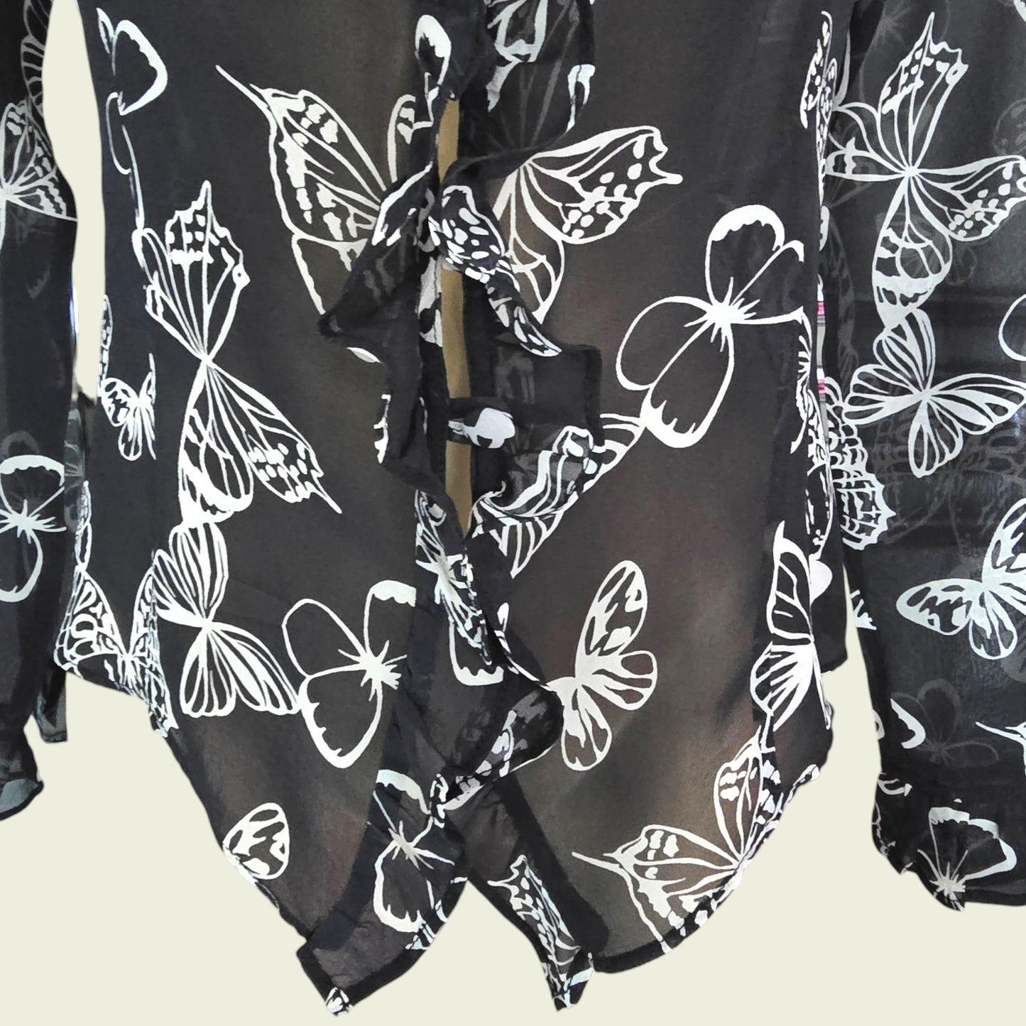 Black garment with white butterfly patterns on a beige background