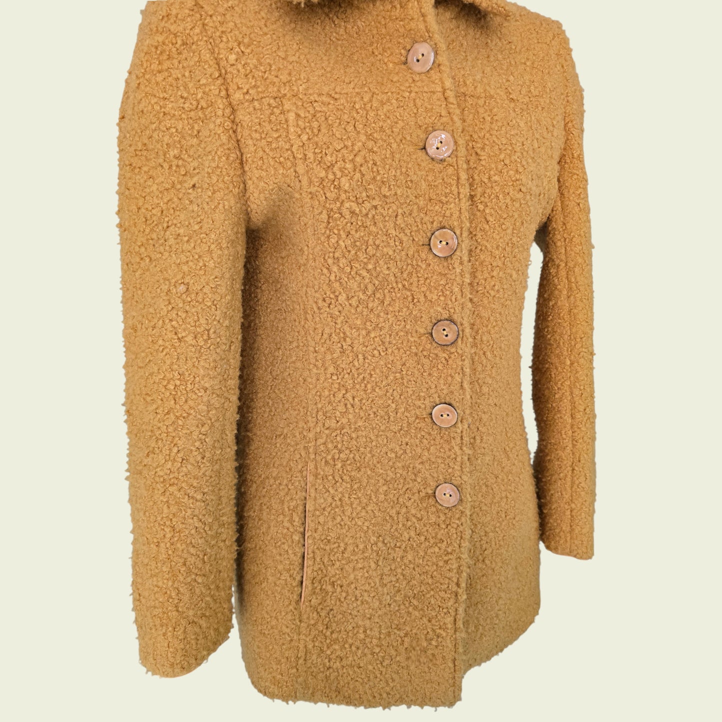 Mannequin wearing mustard coloured jacket on beige background