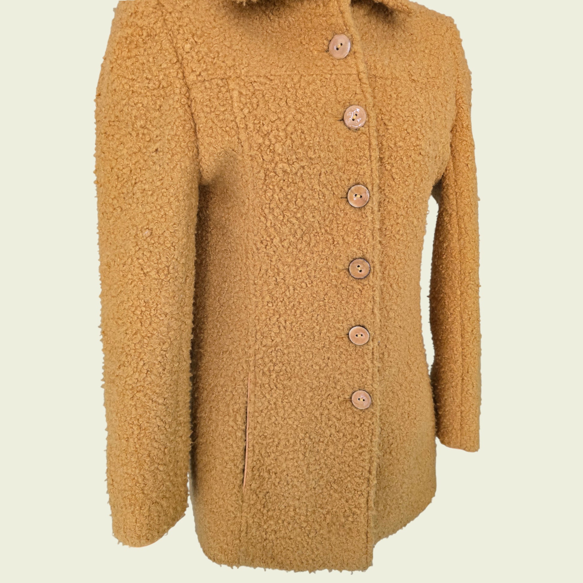 Mannequin wearing mustard coloured jacket on beige background