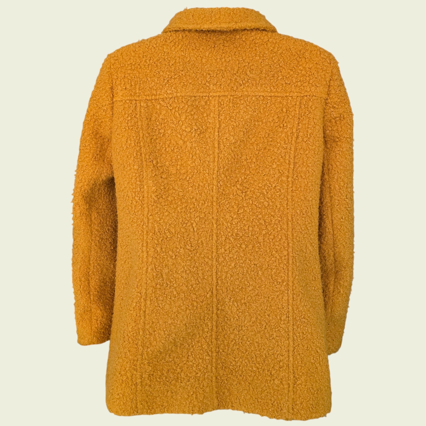 Mannequin wearing mustard coloured jacket on beige background