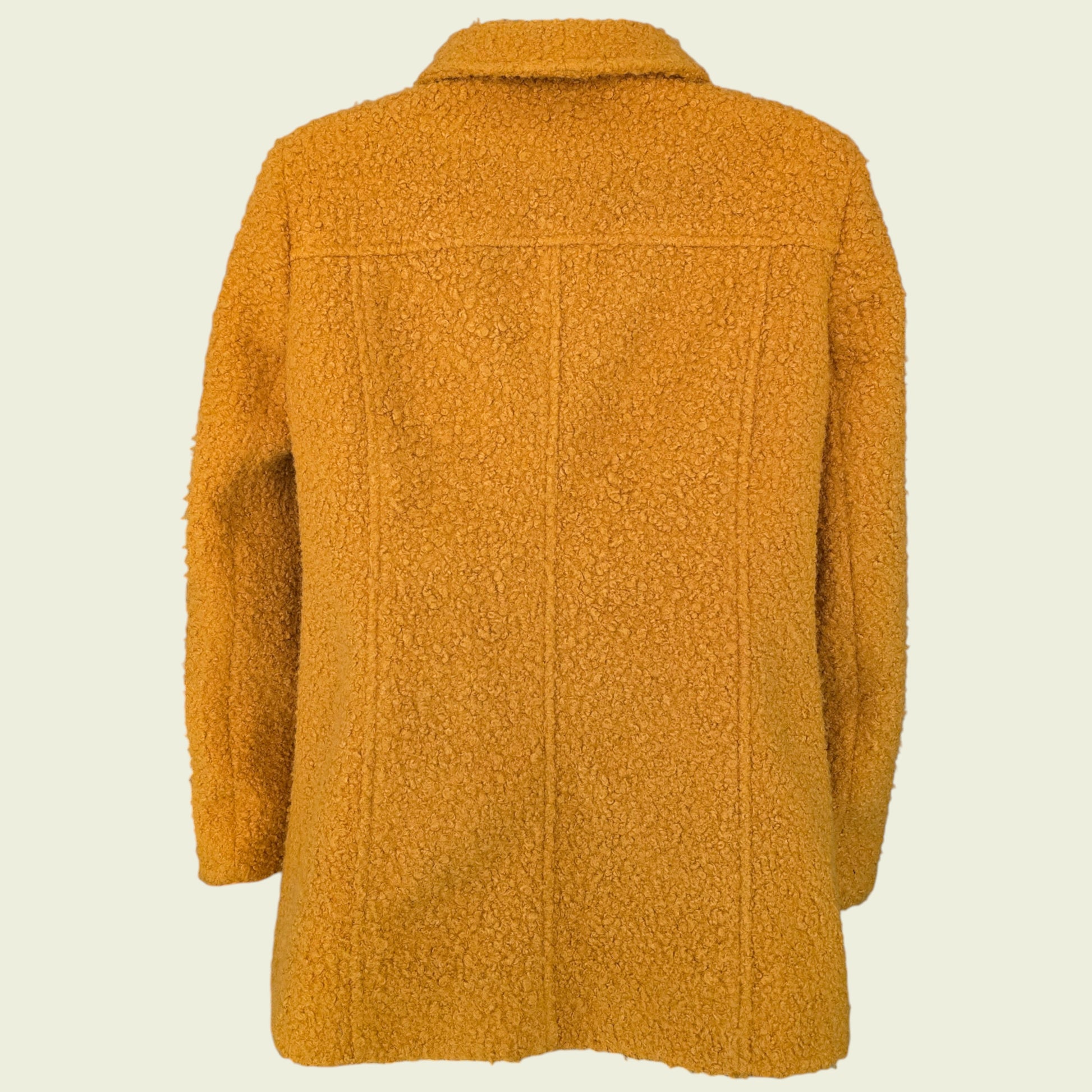 Mannequin wearing mustard coloured jacket on beige background