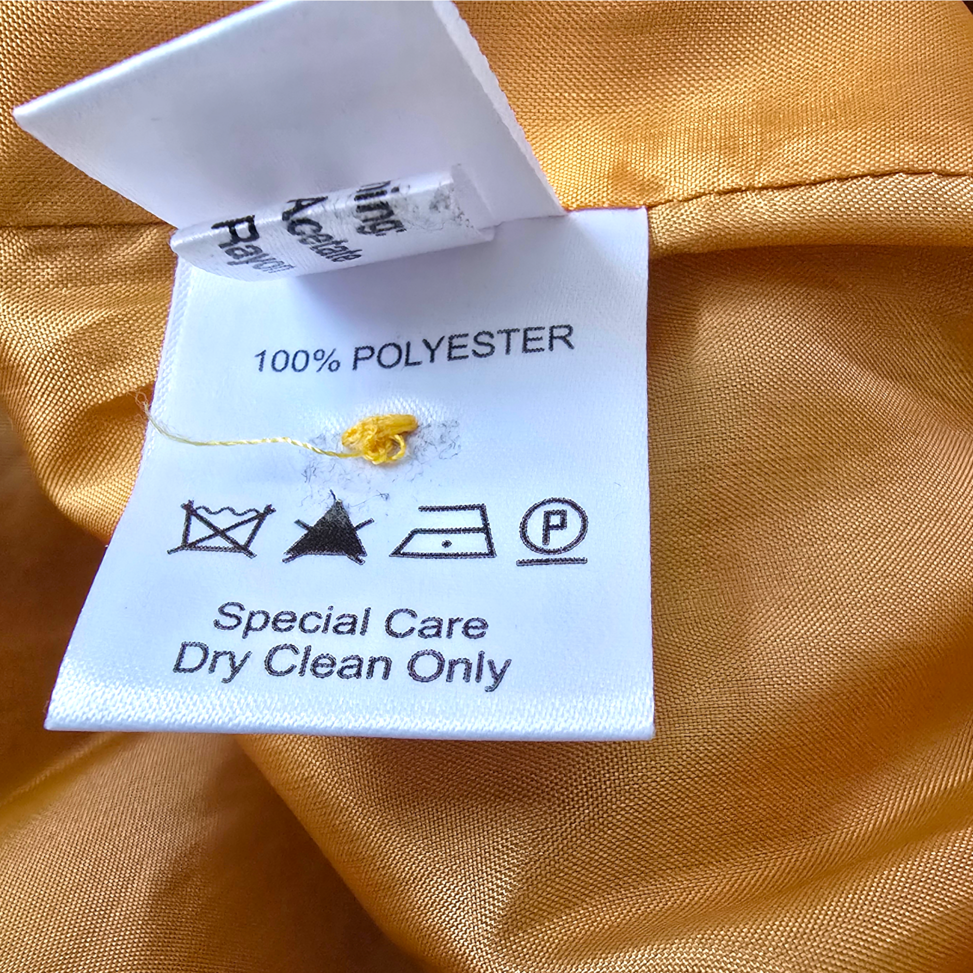 Clothing label on orange fabric with care instructions