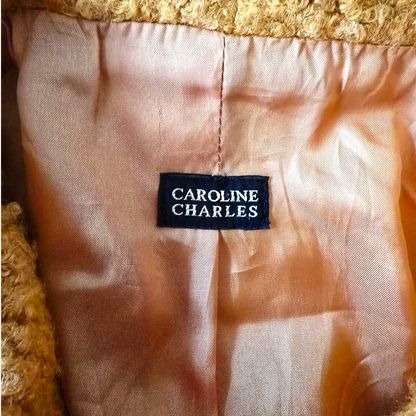 Clothing label with 'Caroline Charles' on a textured fabric background