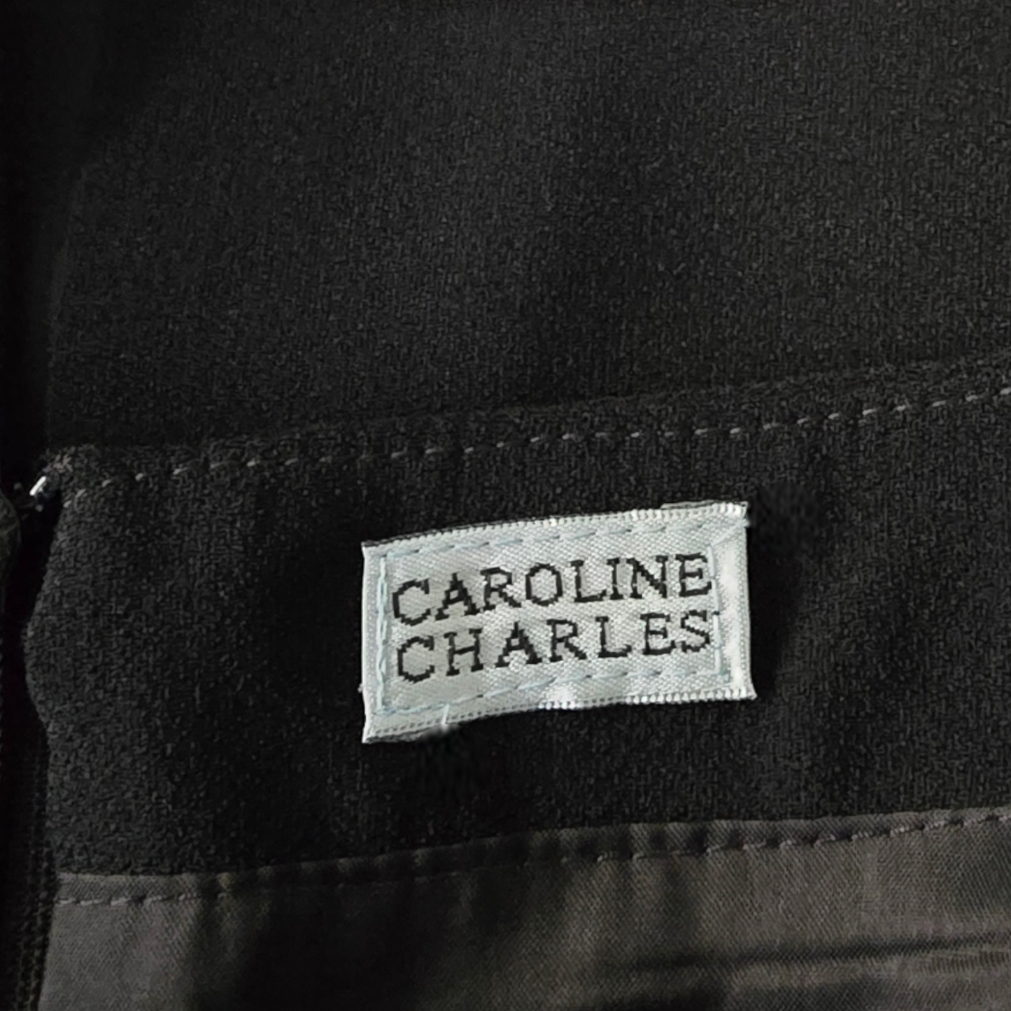 Black fabric with a 'Caroline Charles' label
