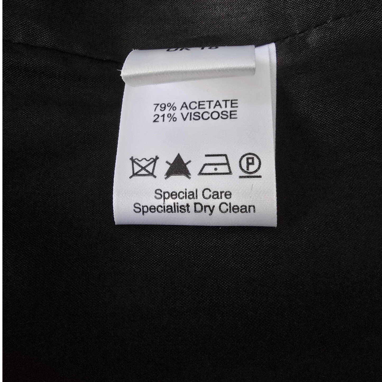 Clothing label with fabric composition and care instructions on a black background