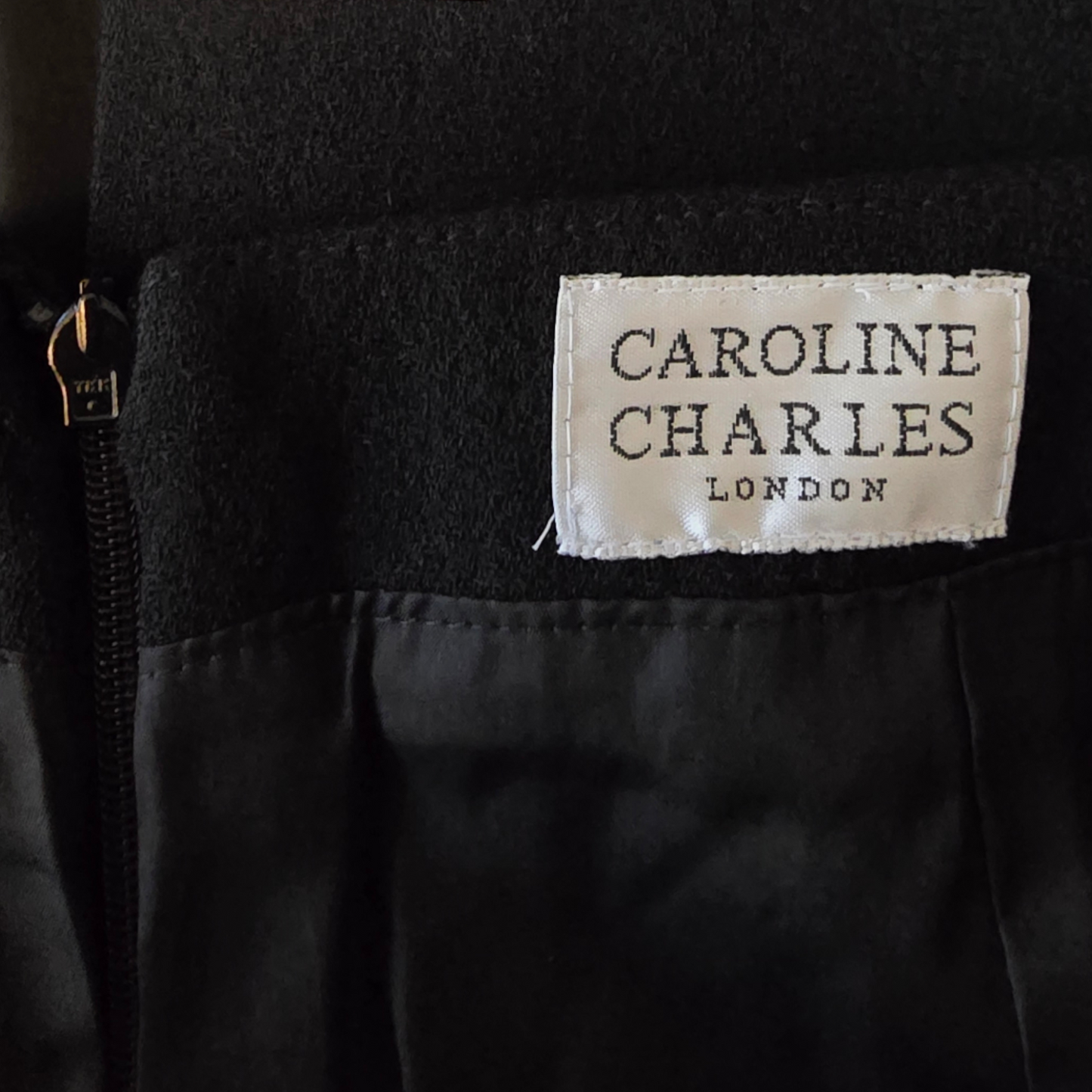 Black fabric with a 'Caroline Charles London' label