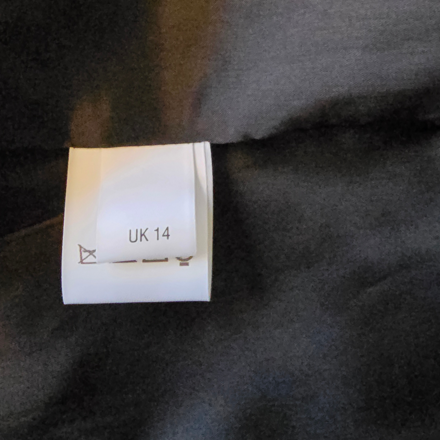 Size label on a dark fabric background