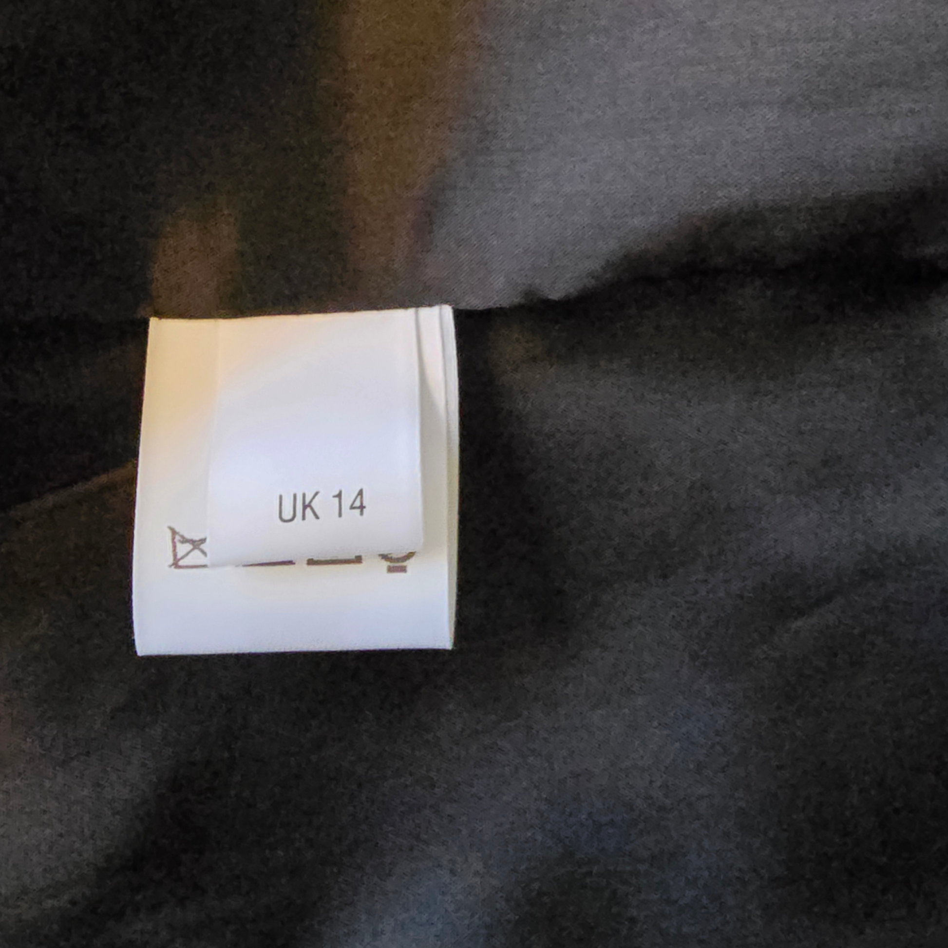 Size label on a dark fabric background