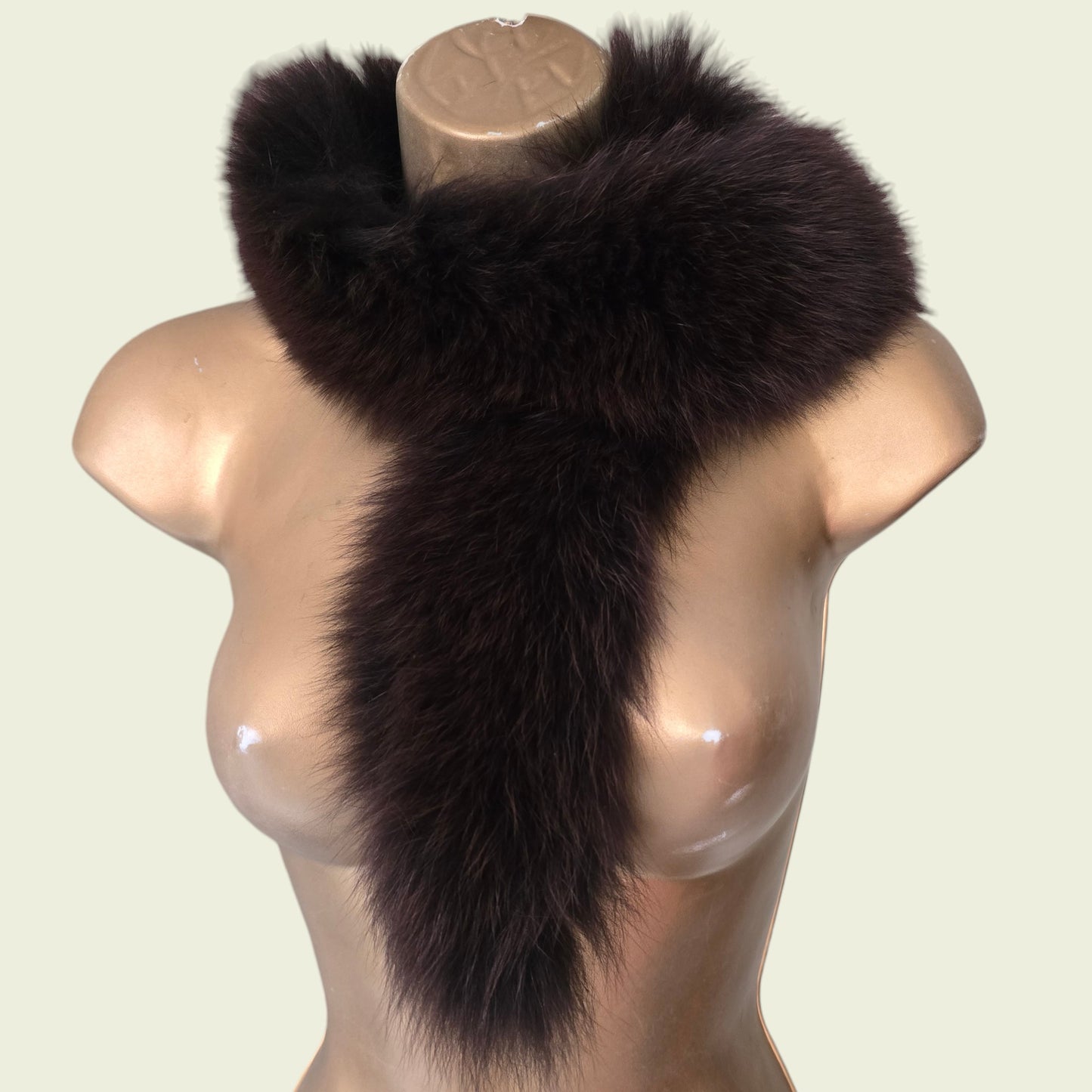 Mannequin wearing brown fur collar, stole on beige background