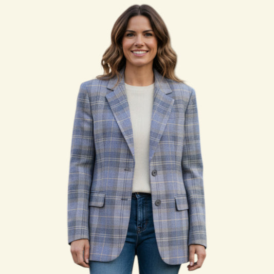 Model wearing blue plaid jacket with blue jeans and white T shirt on beige background
