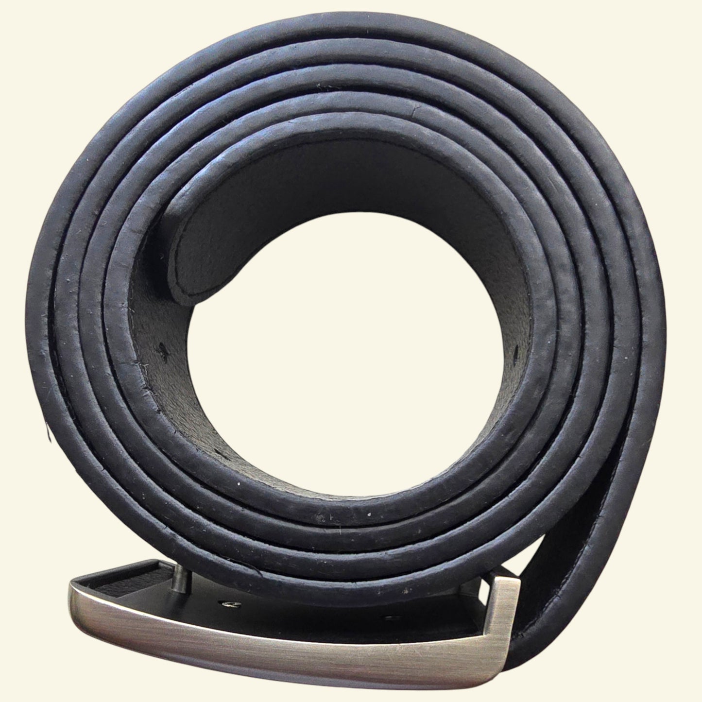 Coiled black leather belt on a beige background