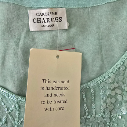 Light green garment with 'Caroline Charles London' label and care instruction tag.