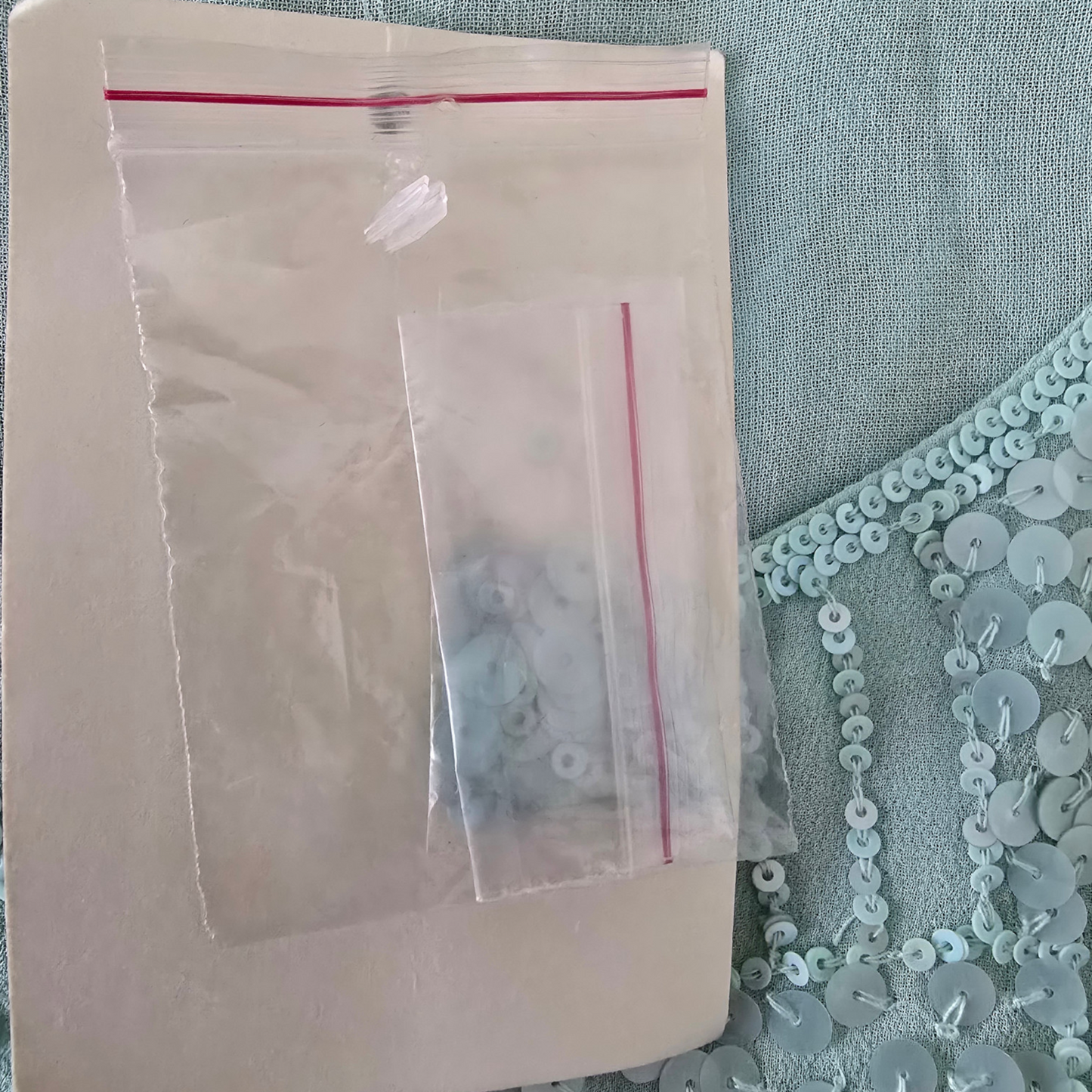 Clear plastic bag with small items inside on a textured surface