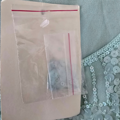 Clear plastic bag with small items inside on a textured surface