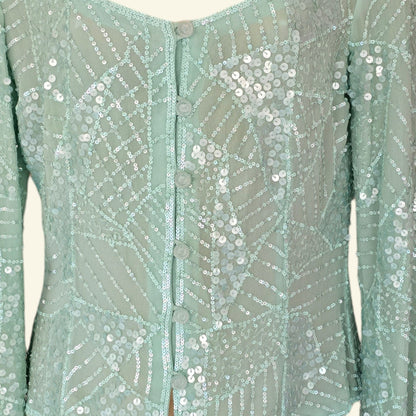 Mint green sequin blouse with buttons on a plain background